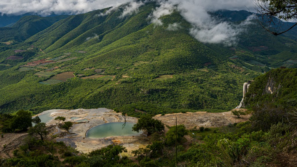 Pond in Limestone Against Green Hill in Hierve El Agua in Mexico